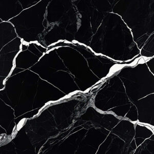 The image is a close-up of a black marble surface with white veins running through it. The veins appear to be irregularly shaped and vary in size and shape, creating a sense of depth and dimension. The black color of the marble is predominantly black, with some areas appearing lighter and darker, while others are lighter and more subtle. The texture of the surface is rough and uneven, with deep grooves and crevices. The overall effect is a striking contrast between the two colors.