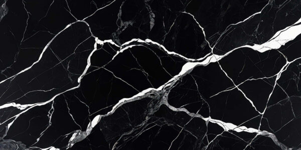 The image is a close-up of a black marble surface with white veins running through it. The veins appear to be irregularly shaped and vary in size and shape, creating a sense of depth and dimension. The black color of the marble is predominantly black, with some areas appearing lighter and darker, while others are lighter and more subtle. The texture of the surface is rough and uneven, with deep grooves and crevices. The overall effect is a striking contrast between the two colors.