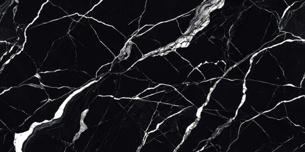 The image is a close-up of a black marble surface with white veins running through it. The veins appear to be irregularly shaped and vary in size and shape, creating a sense of depth and dimension. The black color of the marble is predominantly black, with some areas appearing lighter and darker, while others are lighter and more subtle. The texture of the surface is rough and uneven, with deep grooves and crevices. The overall effect is a striking contrast between the two colors.