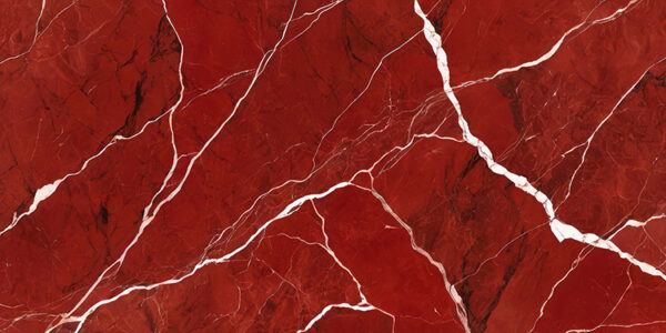 The image is an abstract background with a red and white marble texture. The marble has a deep red color with white veins running through it, creating a wave-like pattern. The veins appear to be jagged and uneven, with some areas appearing darker and others lighter. The texture of the marble is rough and uneven. The overall effect is one of depth and dimension.